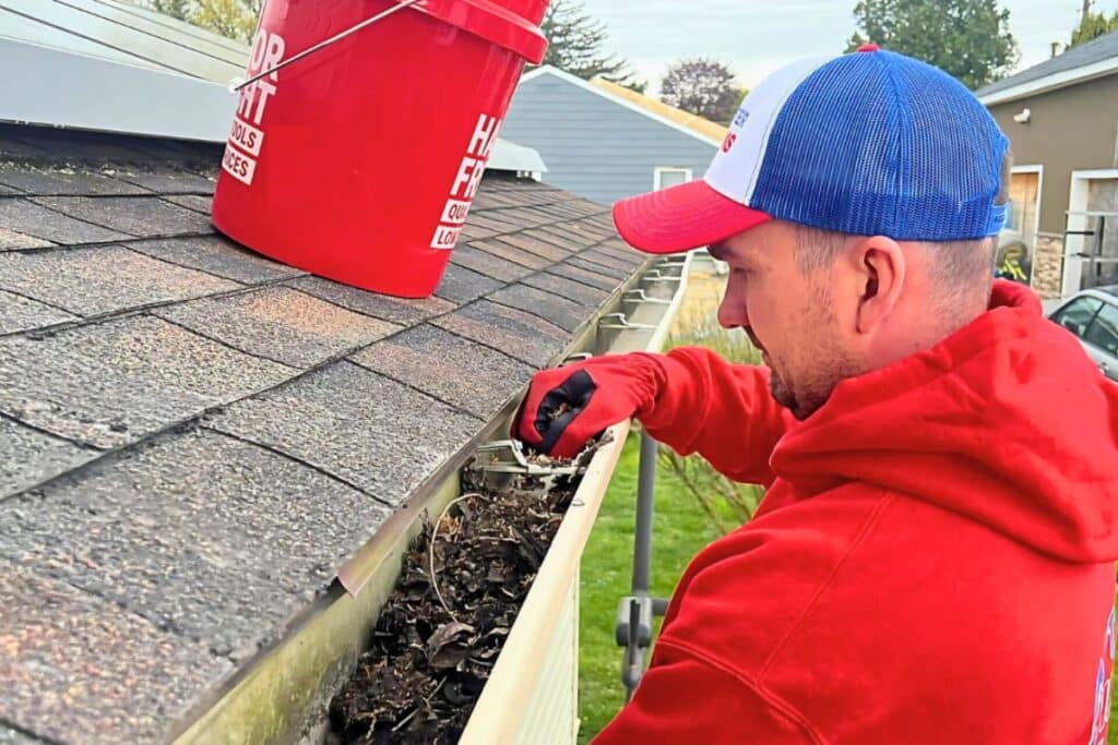 professional gutter cleaning service removing debris from roof gutters