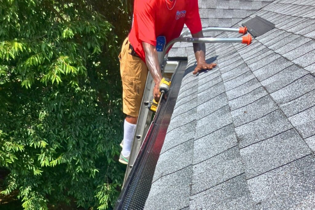 Technician installing gutter guards on residential home in Lehigh Valley to improve drainage and reduce gutter maintenance