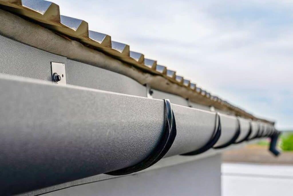 close-up of steel rain gutters mounted along roof edge