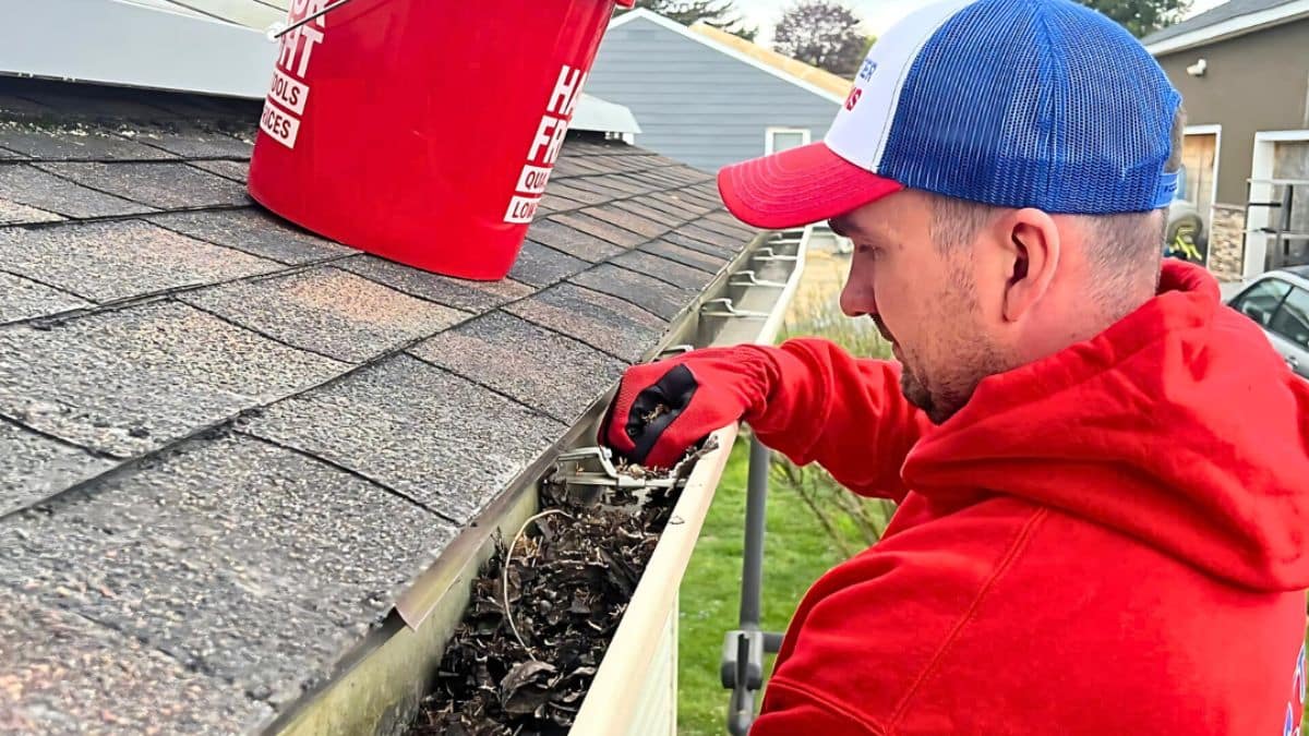 Gutter Twins crew member performing gutter cleaning on a residential gutter